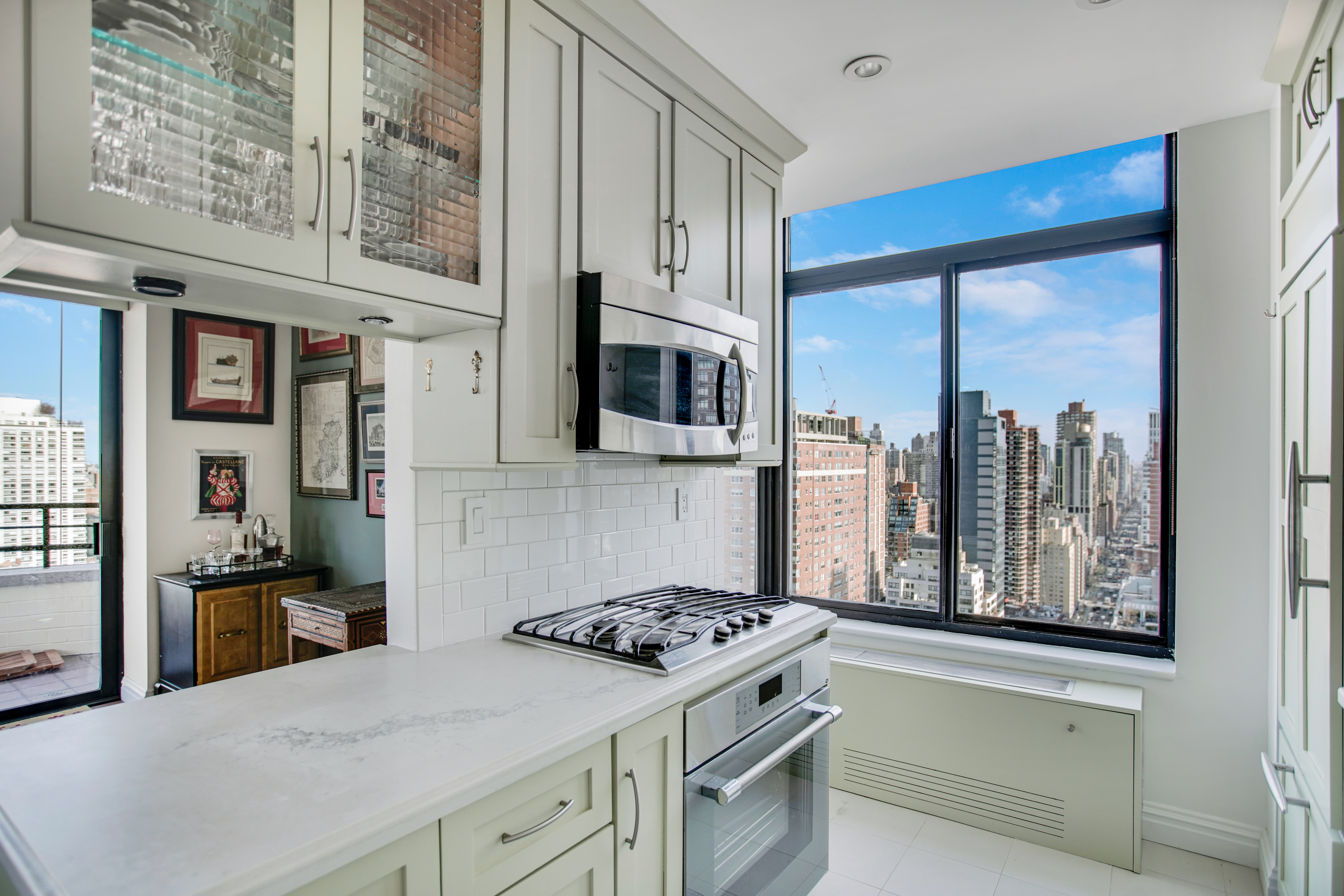 400 East 70th Street, Unit 3301 Manhattan, NY 10021 - Photo 8 of 20 a kitchen with stainless steel appliances granite countertop a stove and a refrigerator