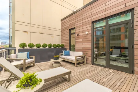 a view of a balcony with chairs and wooden floor