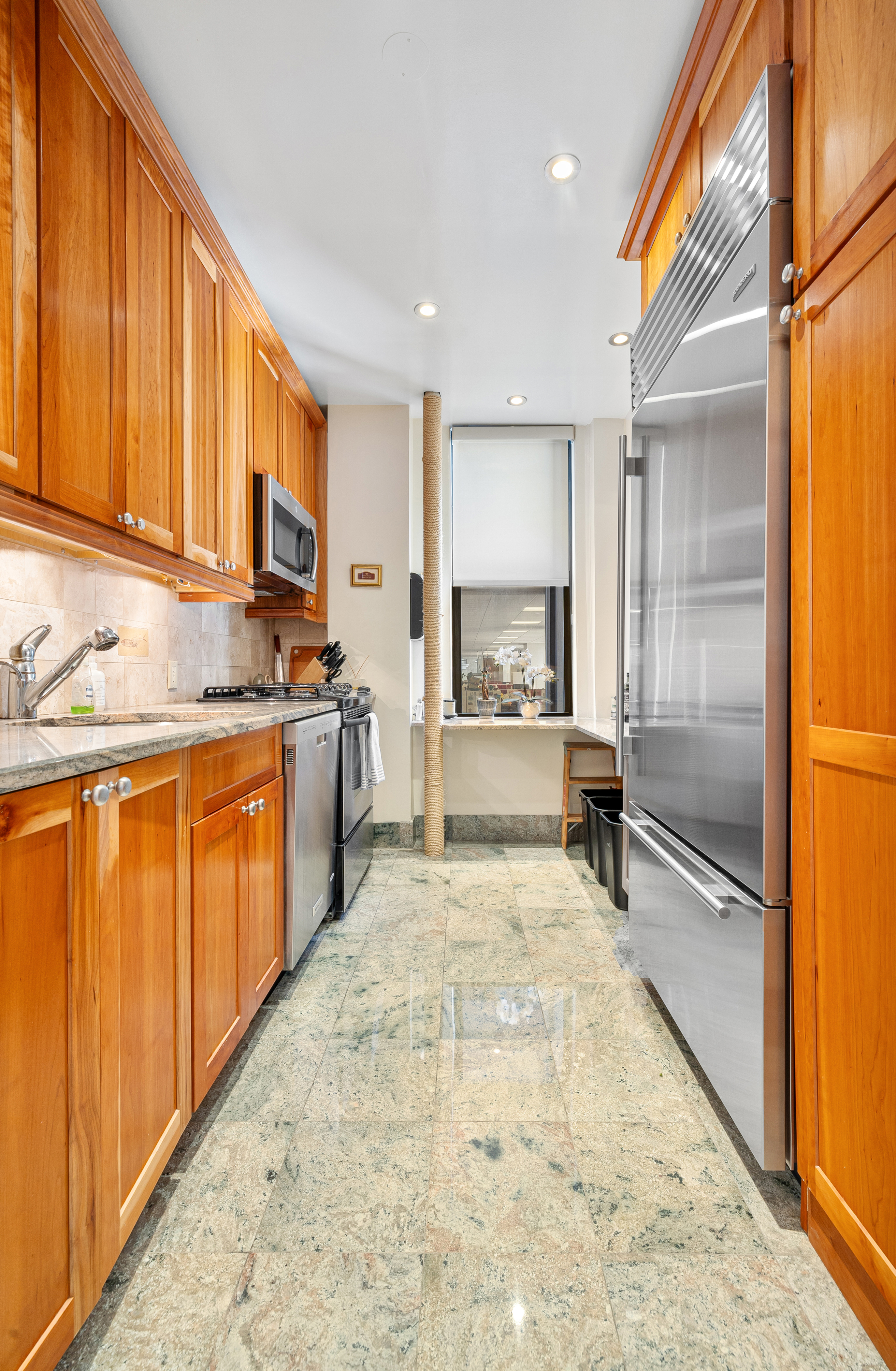 200 West 54th Street, Unit 9G Manhattan, NY 10019 - Photo 13 of 17 a large kitchen with stainless steel appliances granite countertop a stove a sink and a refrigerator