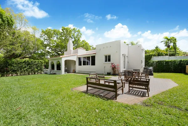 a view of a house with backyard and sitting area