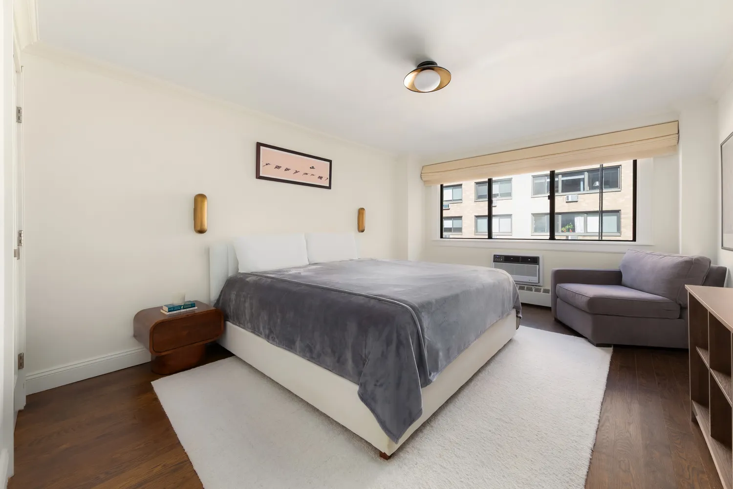 a spacious bedroom with a bed and a couch with window