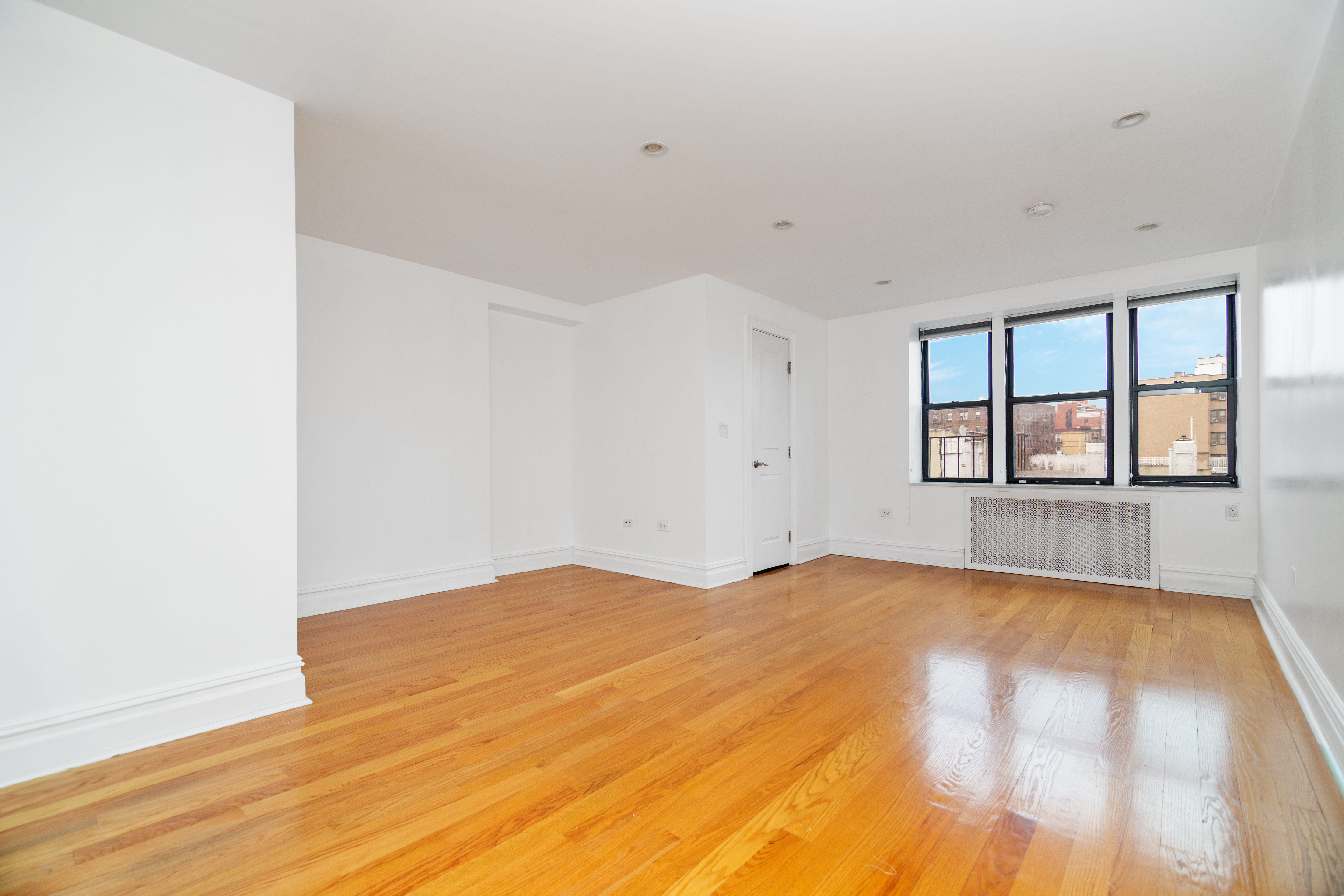 69 Bennett Avenue, Unit 608 Manhattan, NY 10033 - Photo 1 of 6 a view of an empty room with a window and wooden floor