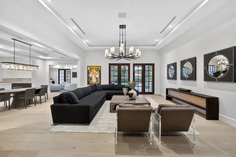 a living room with furniture chandelier and a large window