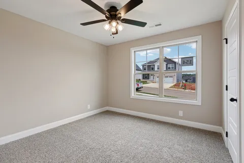 an empty room with windows and fan