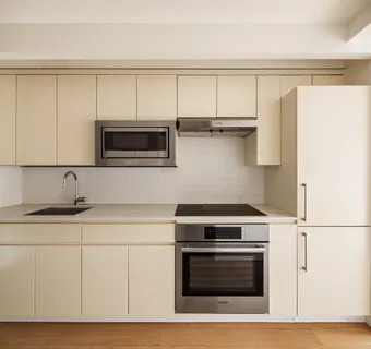 a kitchen with stainless steel appliances a stove a microwave and white cabinets