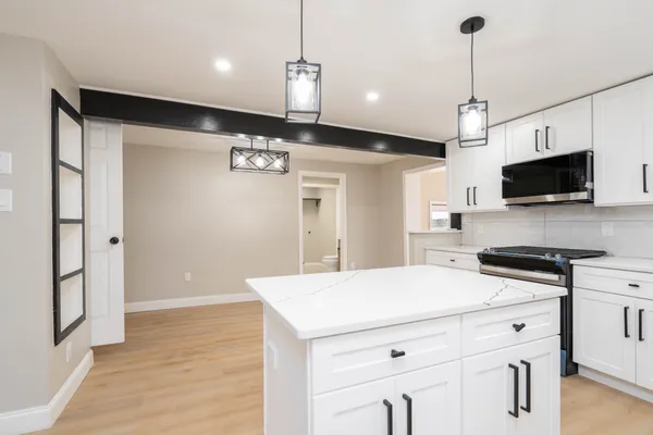 a kitchen that has a microwave a stove and a refrigerator