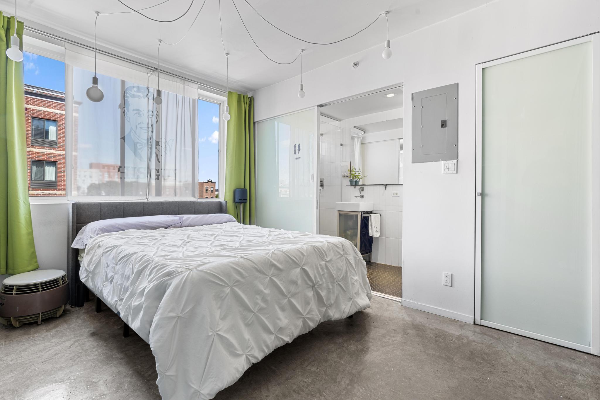 1311 Pacific Street, Unit 405 Brooklyn, NY 11216 - Photo 4 of 9 a bedroom with a bed and a refrigerator