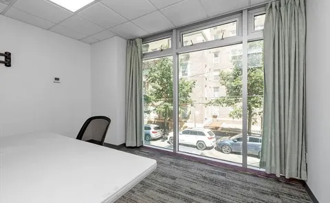 a bedroom with a bed and a large window