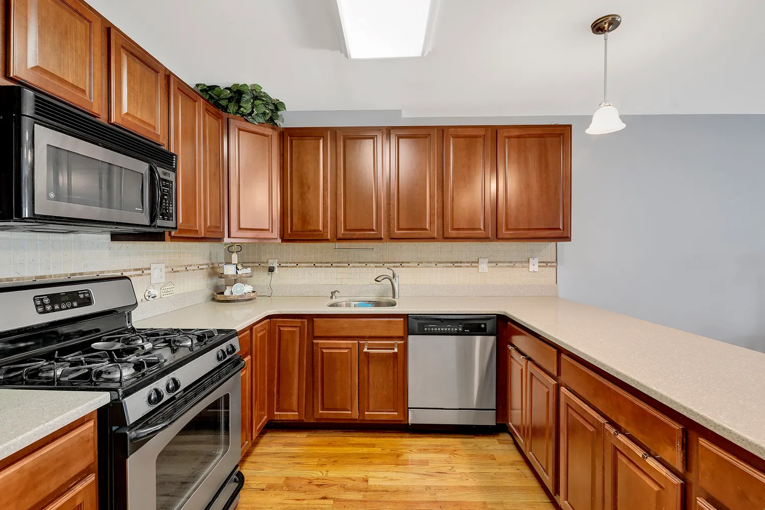a kitchen with stainless steel appliances granite countertop a sink stove and microwave