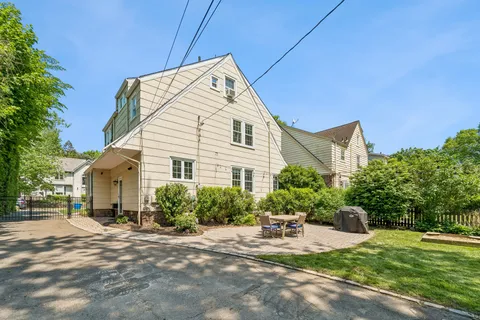 a front view of a house with yard and green space