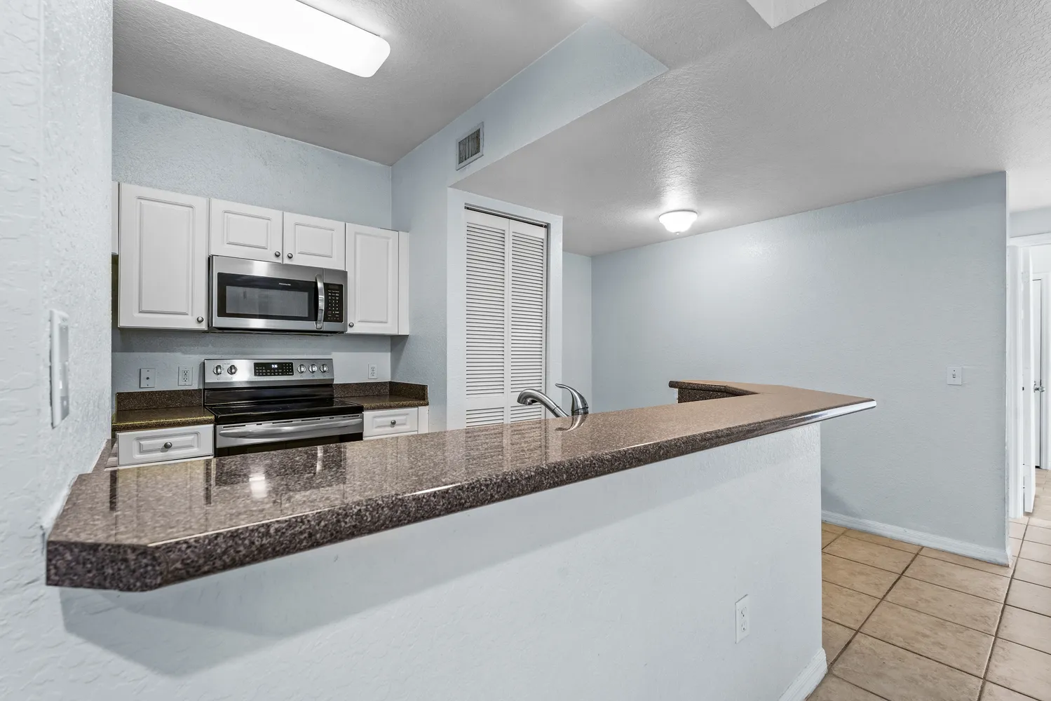 a kitchen with stainless steel appliances a sink and a refrigerator