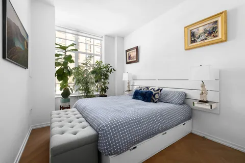a bedroom with a large bed and a potted plant
