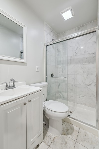671 Metropolitan Avenue, Unit Undisclosed Brooklyn, NY 11211 - Photo 11 of 13 a bathroom with a granite countertop sink toilet and shower