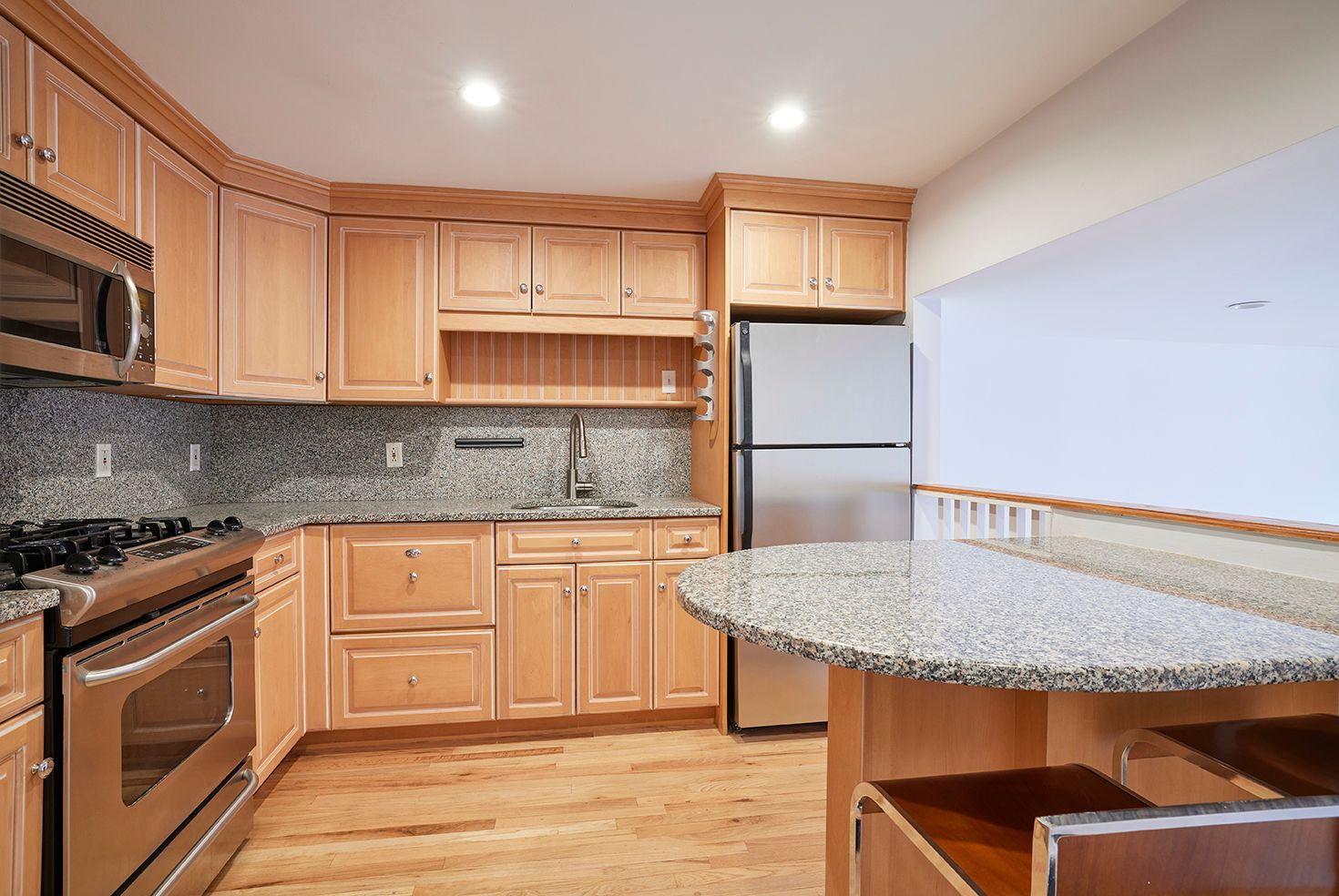 a kitchen with stainless steel appliances granite countertop a stove a sink and a microwave