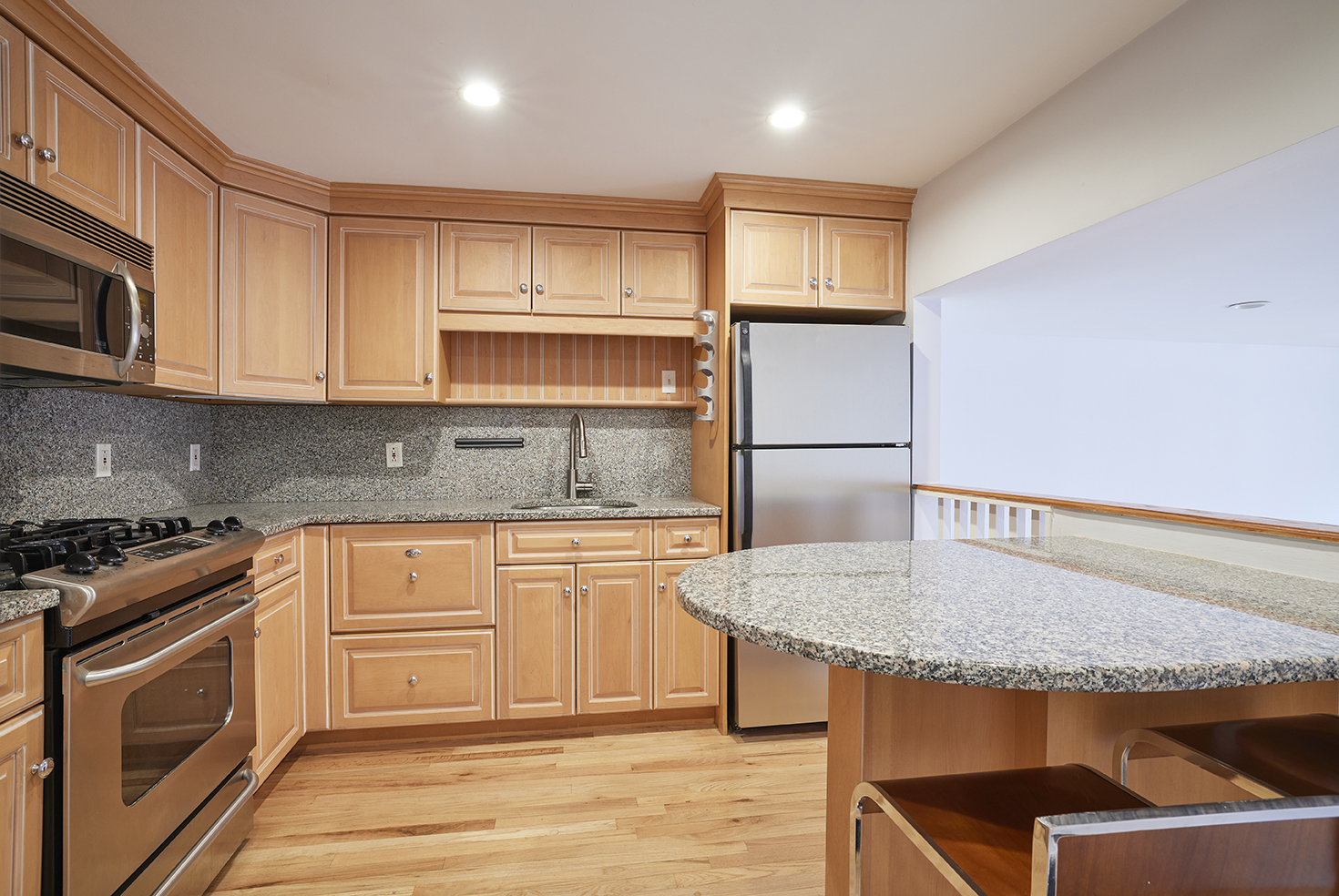 211 Thompson Street, Unit 5L Manhattan, NY 10012 - Photo 2 of 7 a kitchen with stainless steel appliances granite countertop a stove a sink and a microwave