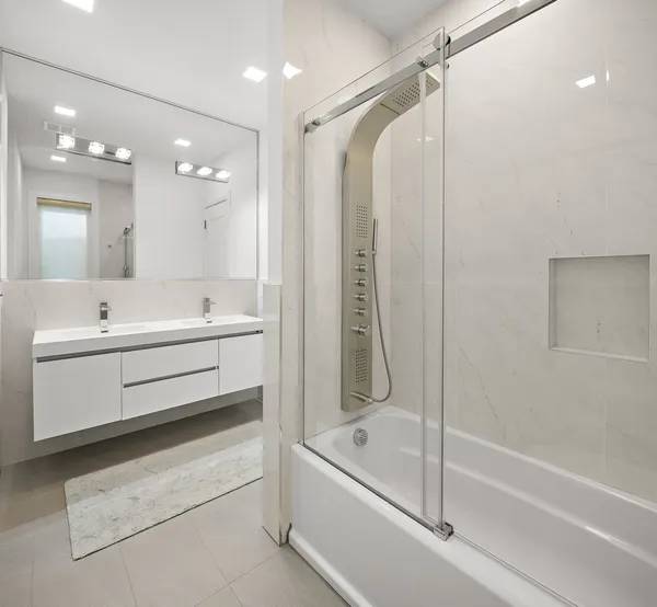a bathroom with a double vanity sink window and a bathtub