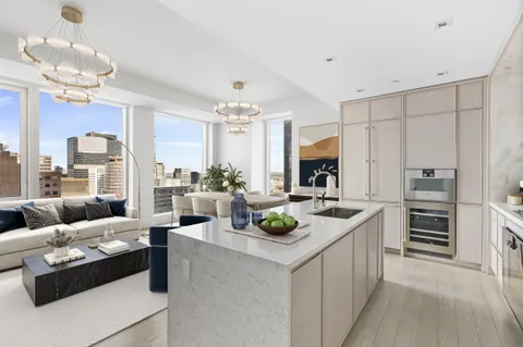 a living room with furniture and a view of kitchen