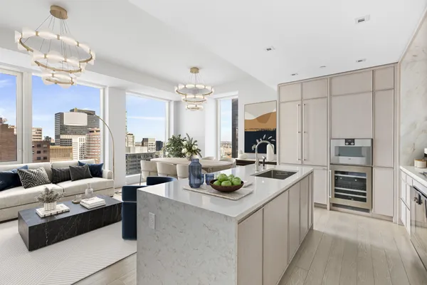 a living room with furniture and a view of kitchen