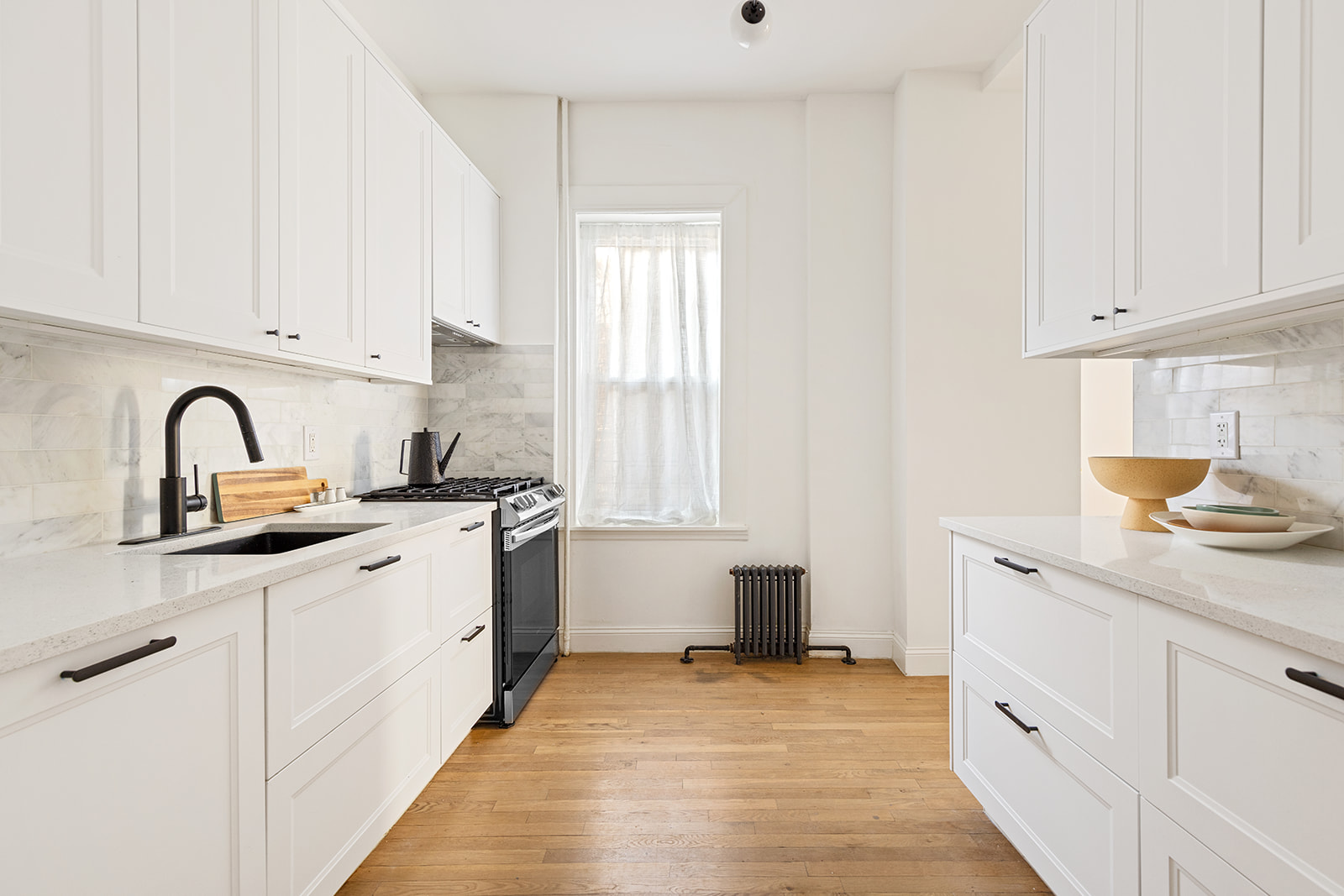 610 Marlborough Road Brooklyn, NY 11226 - Photo 4 of 16 a kitchen with white cabinets appliances and a window
