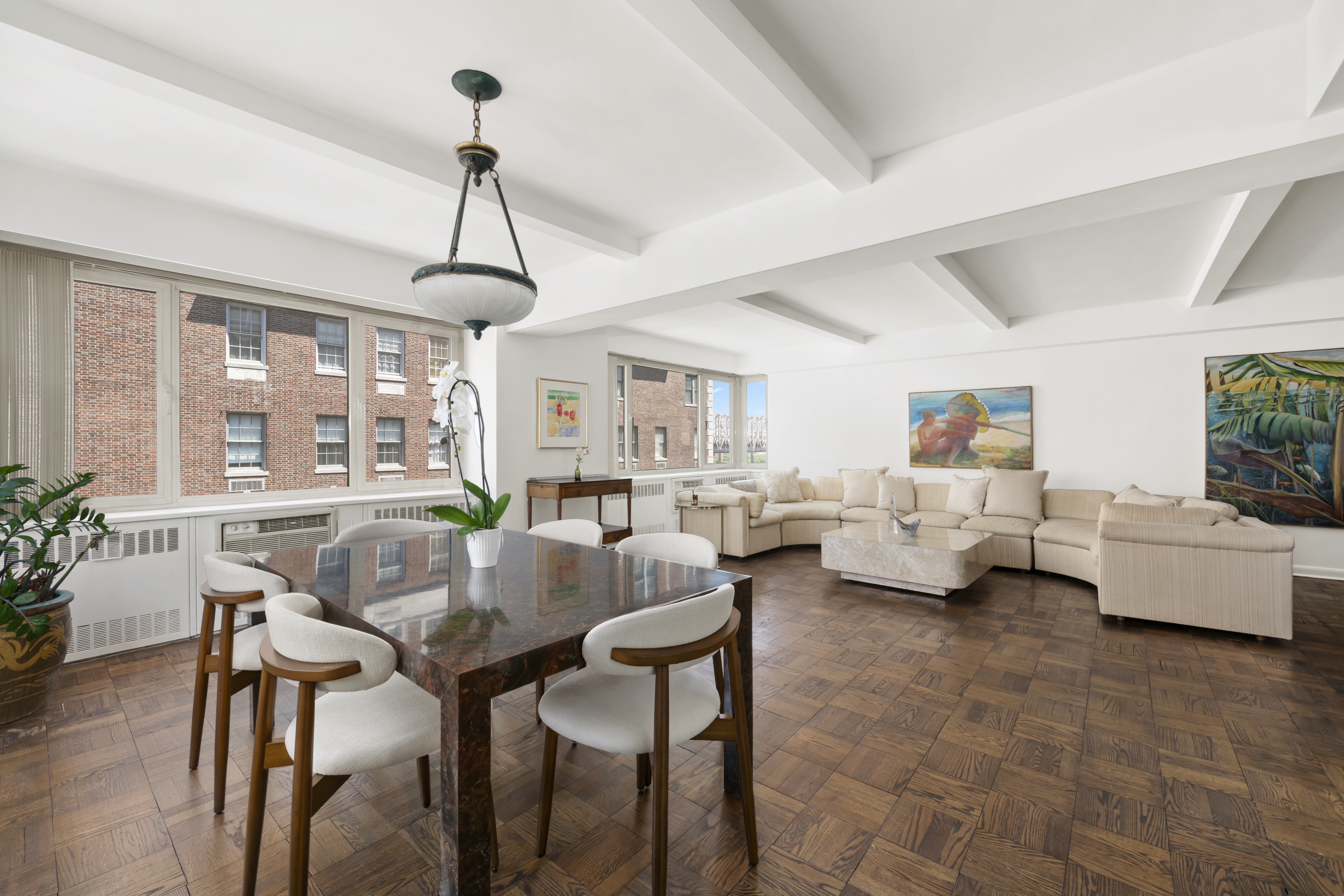 25 Sutton Place South, Unit 16B Manhattan, NY 10022 - Photo 4 of 16 a living room with furniture and a chandelier