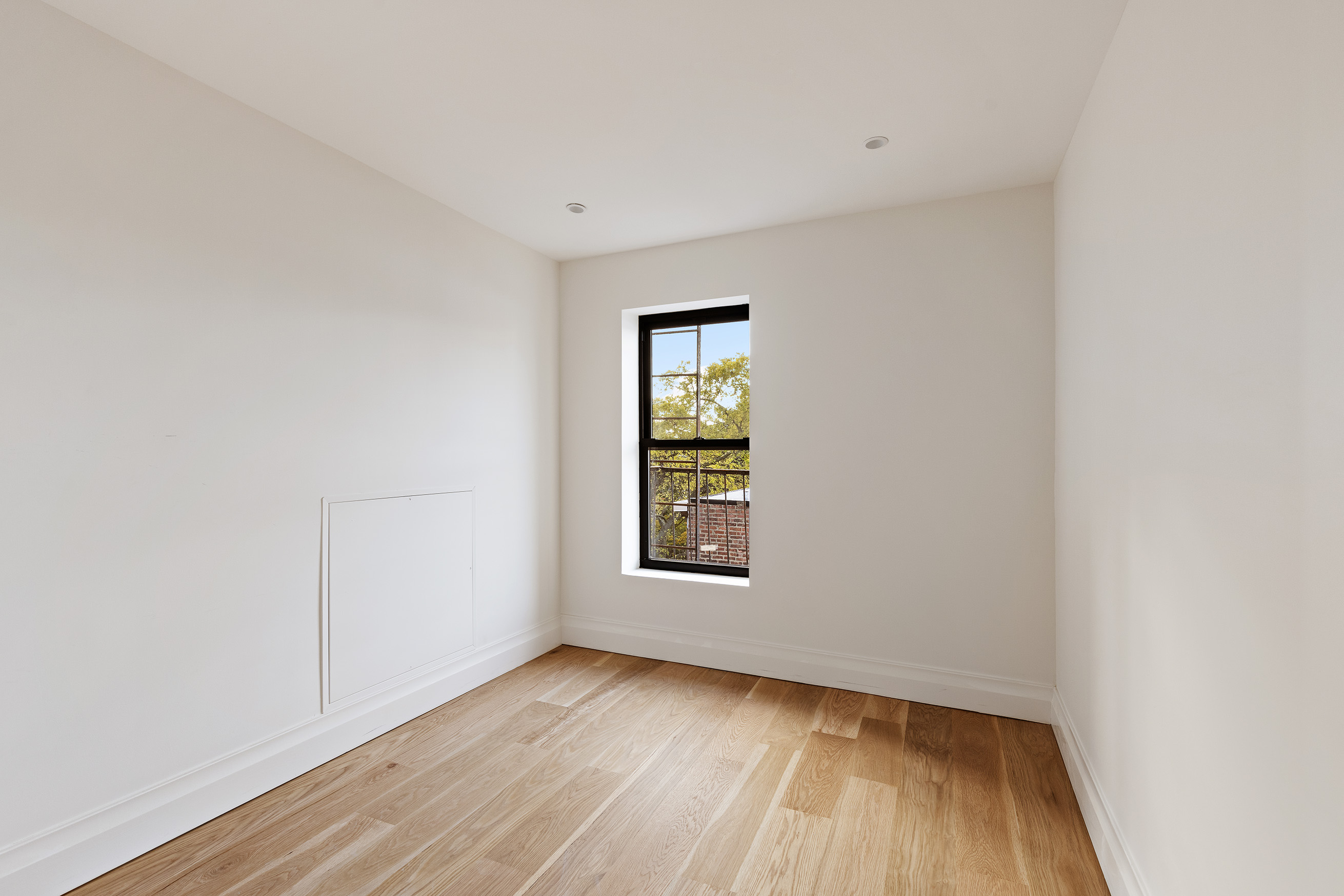 80 7th Avenue, Unit 4 Brooklyn, NY 11217 - Photo 8 of 9 a view of an empty room with wooden floor and a window