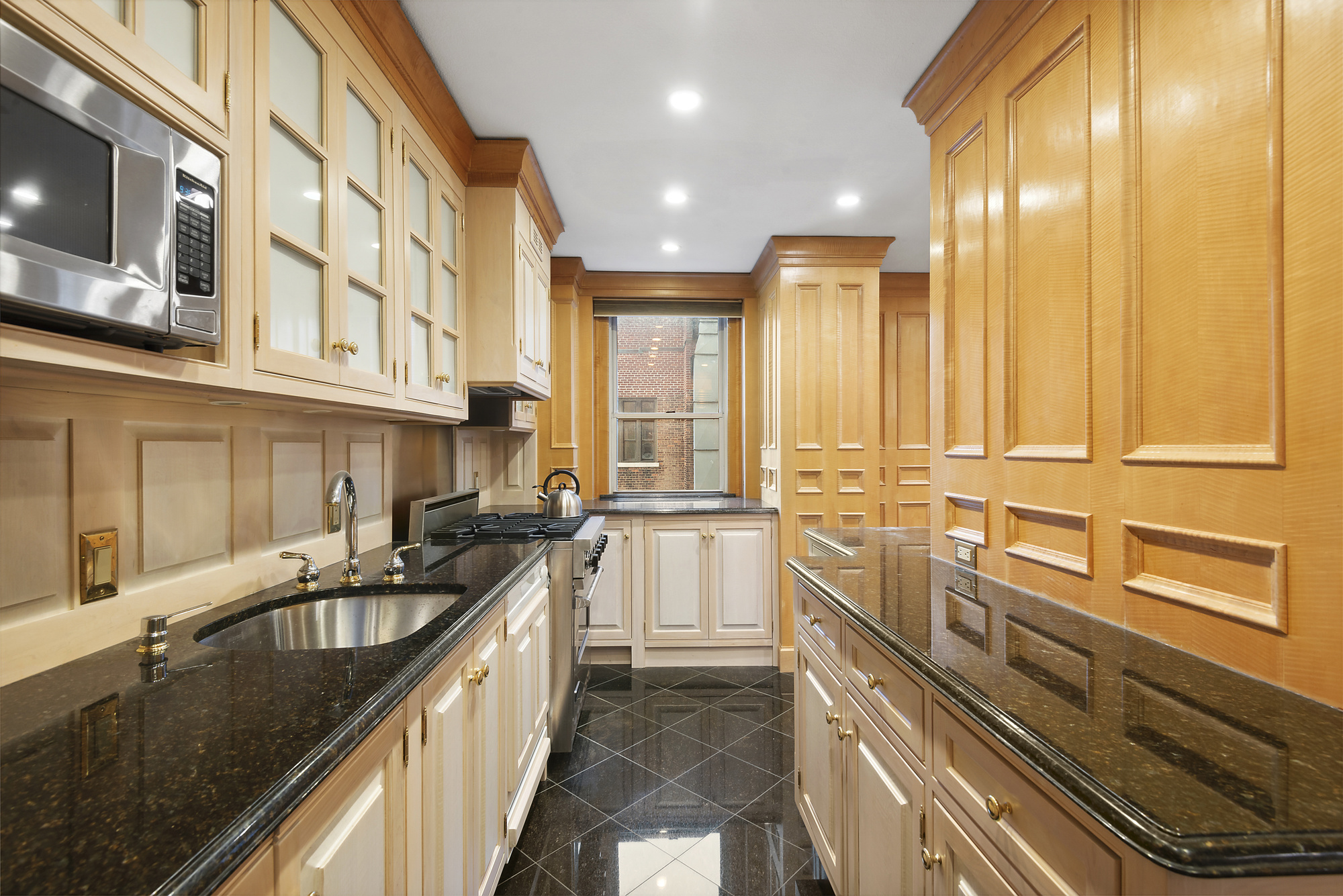 145 West 86th Street, Unit 12B Manhattan, NY 10024 - Photo 7 of 12 a kitchen with stainless steel appliances granite countertop a sink and stove