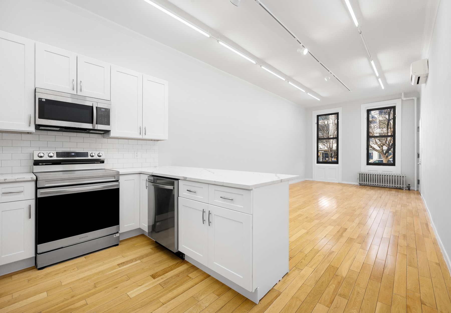 249 East Houston Street, Unit PARLOR Manhattan, NY 10002 - Photo 4 of 12 a kitchen with stainless steel appliances a stove a microwave and sink