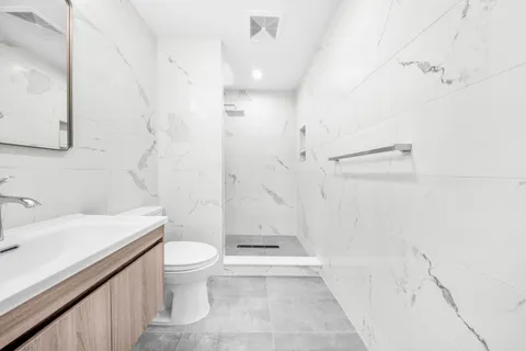 a bathroom with a sink a toilet and shower