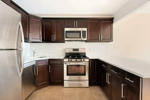 a kitchen with stainless steel appliances a stove microwave and refrigerator