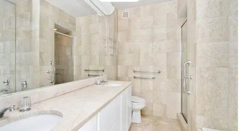 a bathroom with a granite countertop sink a toilet and a shower