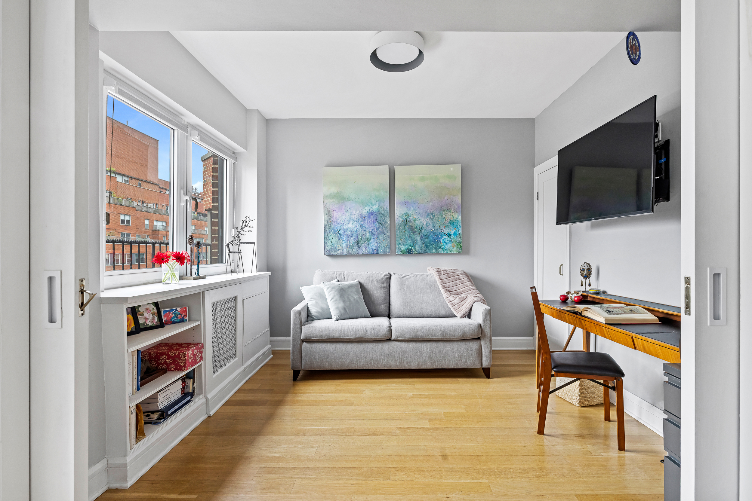 80 East End Avenue, Unit 17C Manhattan, NY 10028 - Photo 2 of 11 a living room with furniture and a flat screen tv
