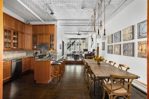 a dining table with chairs and kitchen view