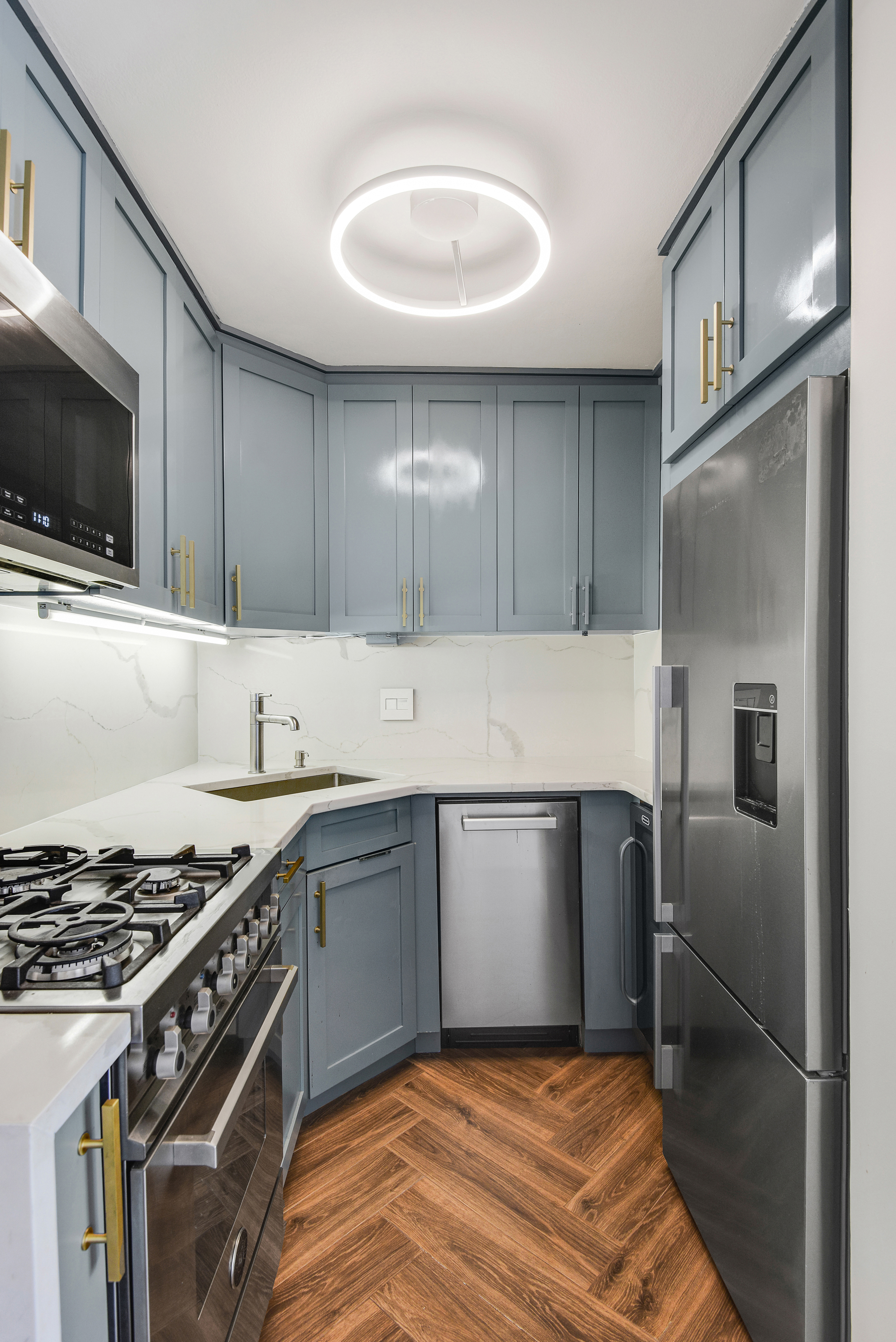 305 East 24th Street, Unit PHL Manhattan, NY 10010 - Photo 3 of 10 a kitchen with granite countertop a sink stove and refrigerator