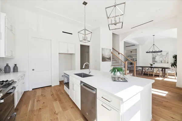 a view of a kitchen with kitchen island a sink wooden floor and living room view