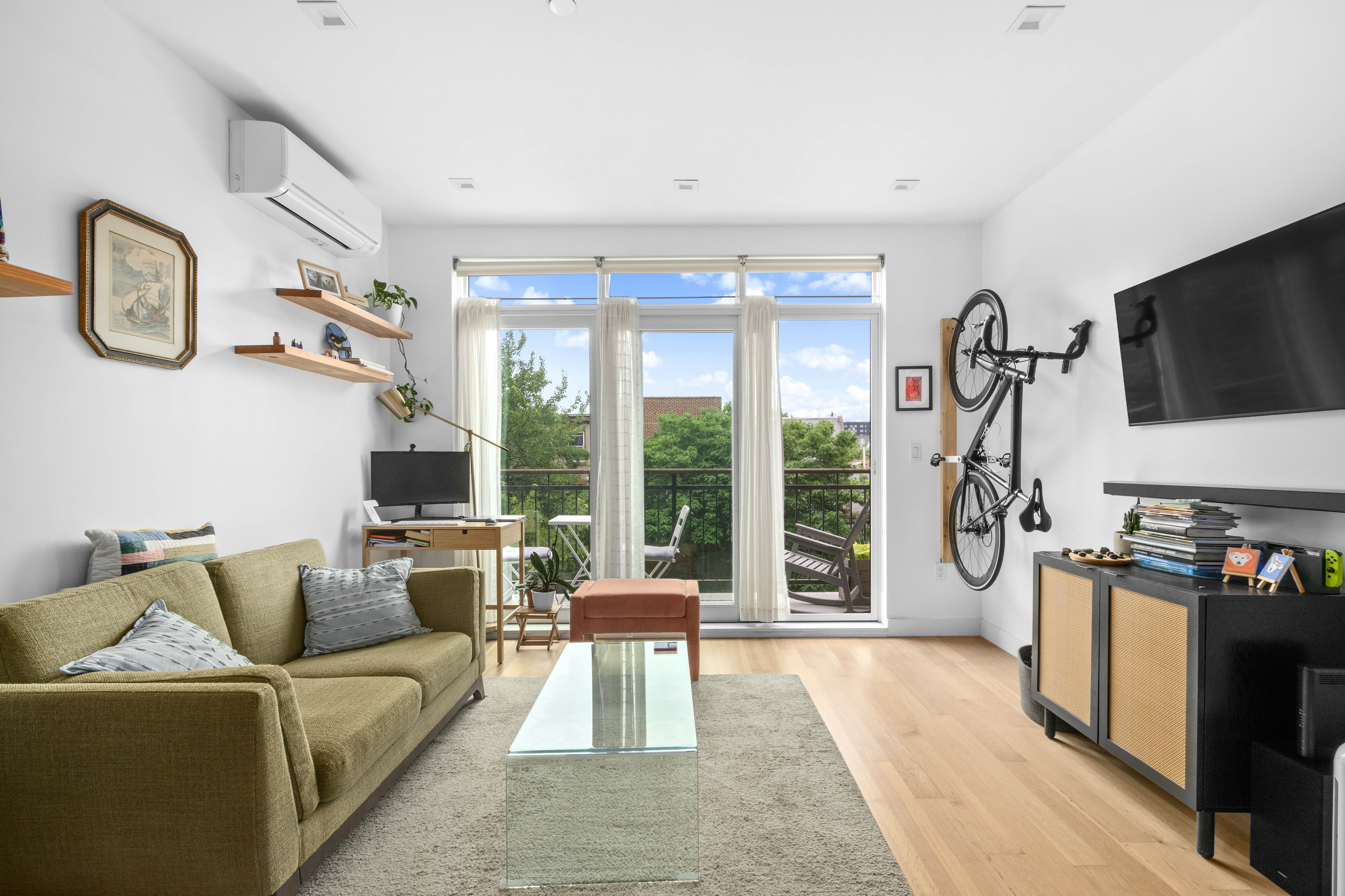 203 Quincy Street, Unit 4B Brooklyn, NY 11216 - Photo 2 of 11 a living room with furniture a flat screen tv and a floor to ceiling window