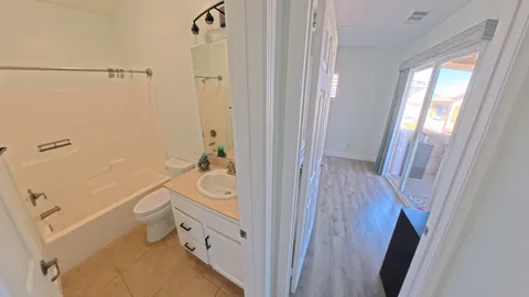 a bathroom with a tub a sink and a large mirror