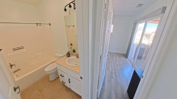 a bathroom with a tub a sink and a large mirror