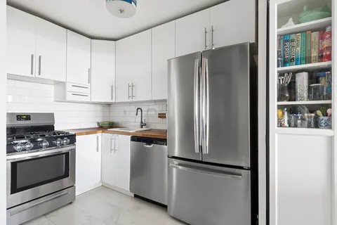 a kitchen with stainless steel appliances a refrigerator stove and cabinets