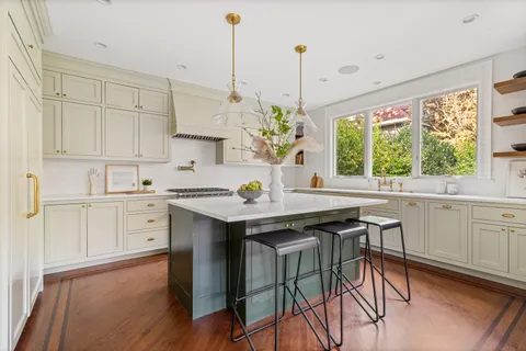 a kitchen with stainless steel appliances a stove and a wooden floor