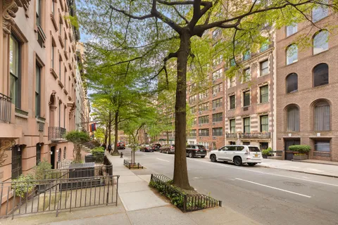 a city street lined with parked cars and buildings