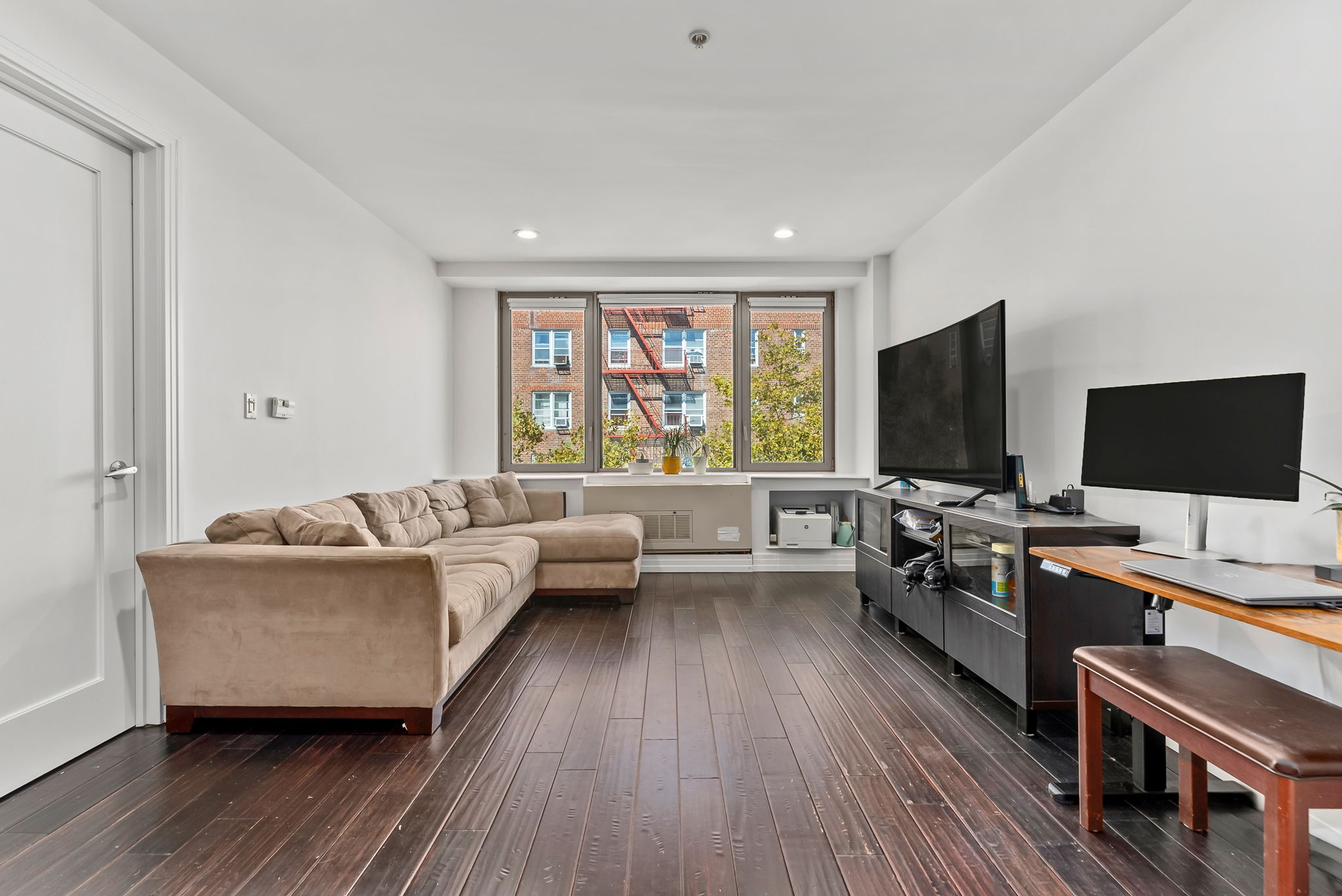 64-05 Yellowstone Boulevard, Unit 414 Queens, NY 11375 - Photo 8 of 14 a living room with furniture and a flat screen tv