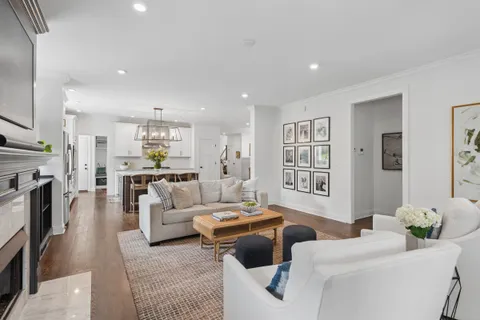 a kitchen with stainless steel appliances a dining table chairs and wooden floor
