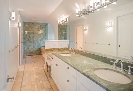 a bathroom with a granite countertop sink a large mirror and a shower