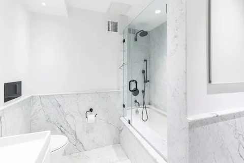 a bathroom with a granite countertop shower and a sink