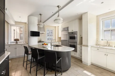 a kitchen with a sink stainless steel appliances and white cabinets