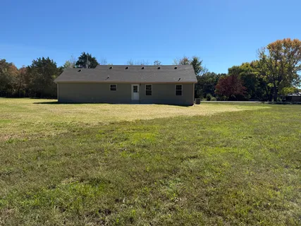 a view of a field with trees in background