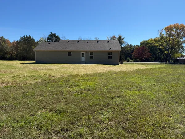 a view of a field with trees in background