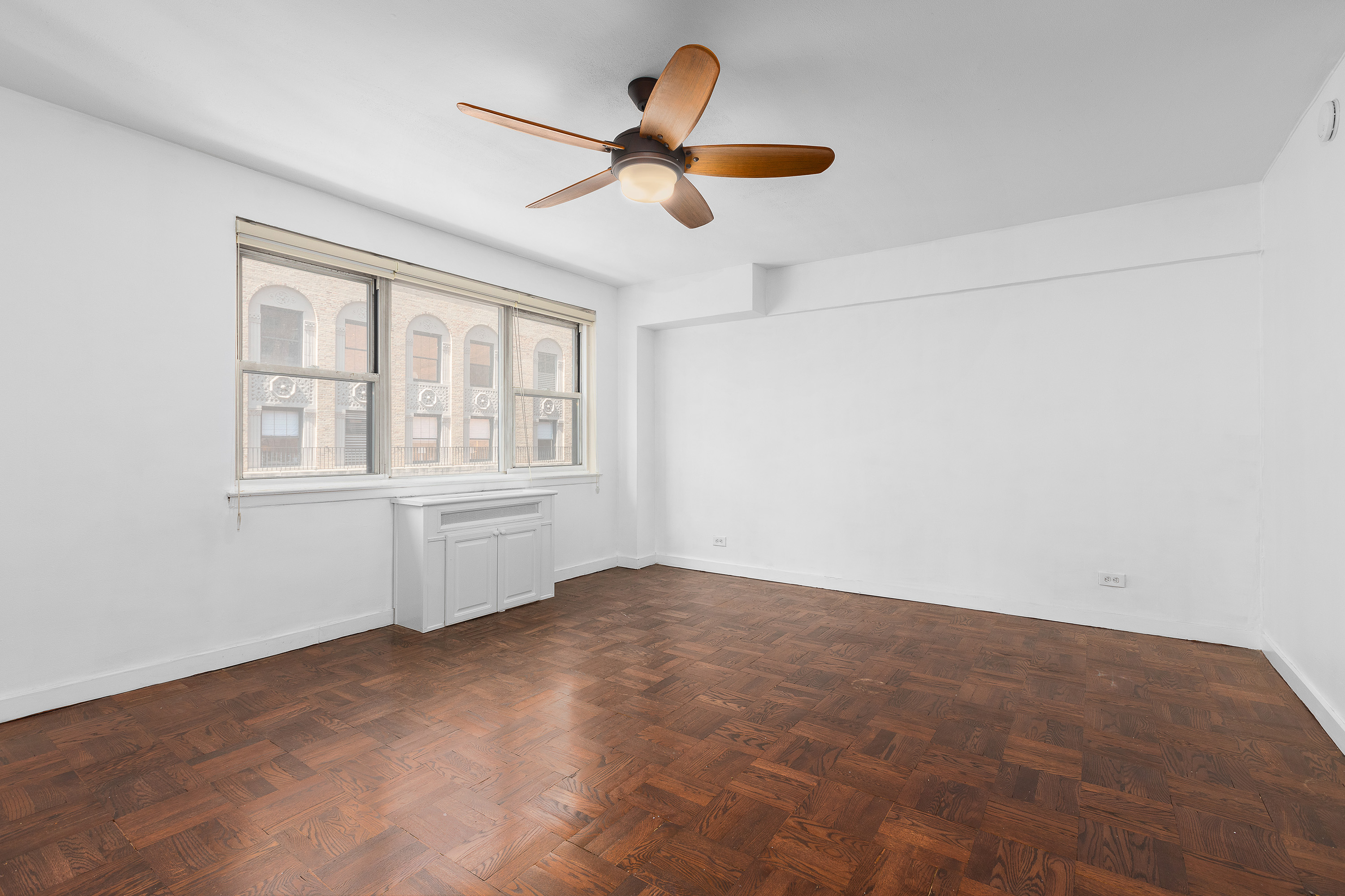 139 East 33rd Street, Unit 15G Manhattan, NY 10016 - Photo 2 of 11 an empty room with window and ceiling fan