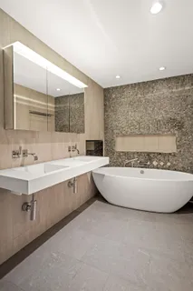 a spacious bathroom with a double vanity sink mirror and bathtub