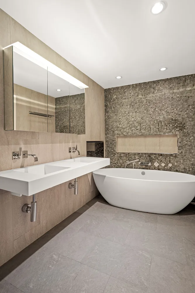 a spacious bathroom with a double vanity sink mirror and bathtub